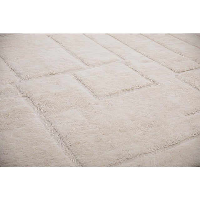Refined hand-knotted wool rug in Pearled Ivory, featuring an abstract geometric pattern with subtle texture. Its soft...