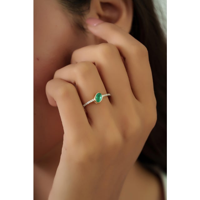 This dainty ring features a 0.5 carat oval-cut emerald set in 14K yellow gold. The emerald measuring 4 x 5.8 mm, elegantly...