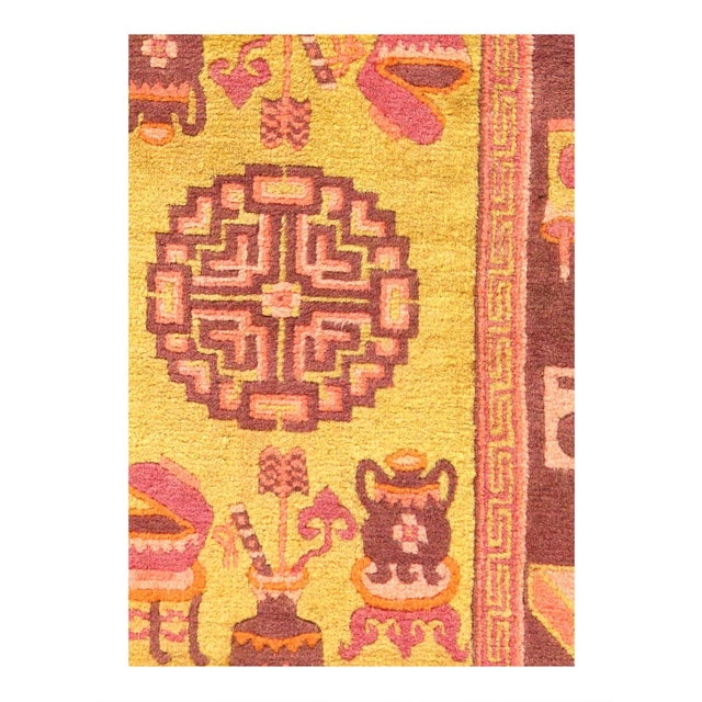 A antique Chinese oriental rug, s circa 1920. This lovely small decorative carpet features a GOLD central field with a...