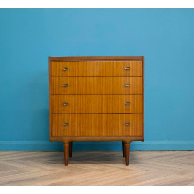 A teak and walnut high gloss finish chest of drawers from Wrighton features two mirrors There are four drawers with metal...
