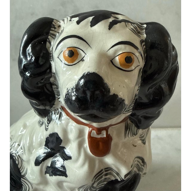 Antique Staffordshire style ceramic sitting spaniel dog figurine featuring hand painted black and white markings,...