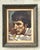 This framed portrait captures a moment of quiet poise and introspection—a man leans slightly forward, arms crossed on a...