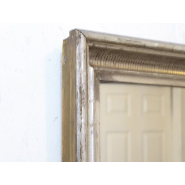 This 19th Century silverleaf mirror has a reeded stencil design and measures 16"H x 14.25"W.