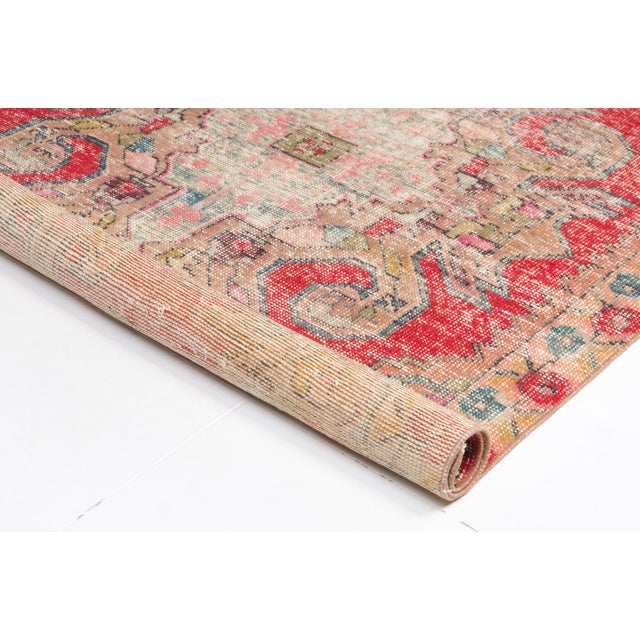 This is a vintage Turkish Oushak rug from the Mid 20th Century. The piece was hand-knotted.