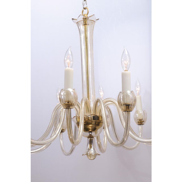 This is a graceful Venetian chandelier featuring sweeping glass S-arms and delicate, tulip-shaped candle cups. The fluid...