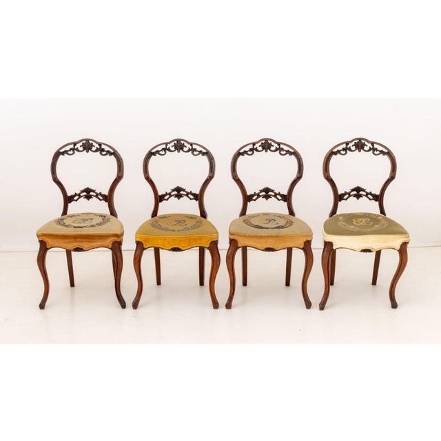 Set of Four Elizabeth II Needlepoint Upholstered Mahogany Chairs, circa 1953, the pierced backs carved with floral motifs....