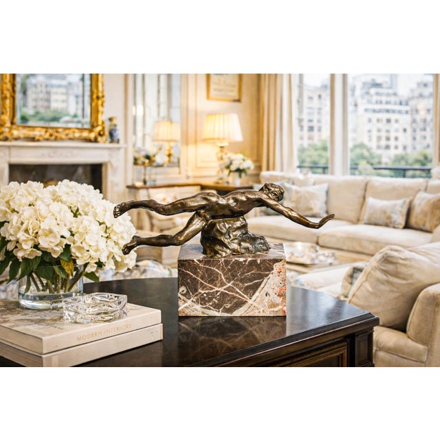 A striking study in movement and form, this vintage bronze sculpture captures the athletic grace of a man suspended in...