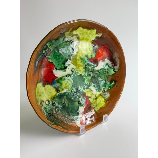 A striking mid-century fused-glass art bowl featuring an expressive abstract surface in swirling tones of emerald green,...