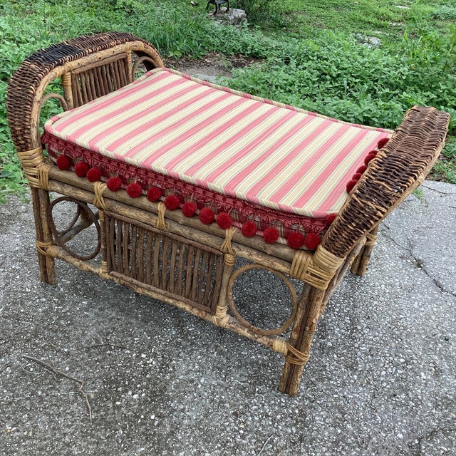 Classical Bohemian Rattan and Bamboo bench. Accented with red striped cushion and red pom-poms. An excellent accent piece...