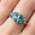Romantic and eye-catching, this elegant Dual Heart Blue Topaz Ring is a stunning expression of love, clarity, and timeless...