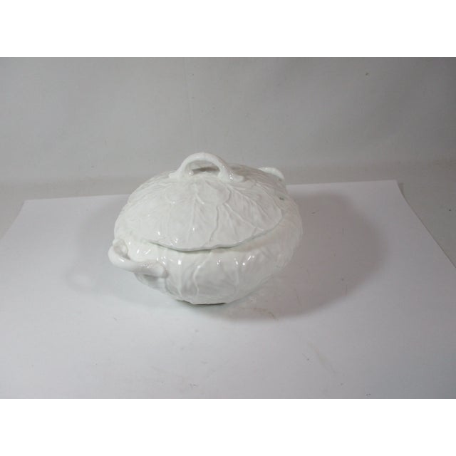 A bone china tureen with lid in the countryware pattern by Coalport of England. It has an all-white embossed cabbage leaf...