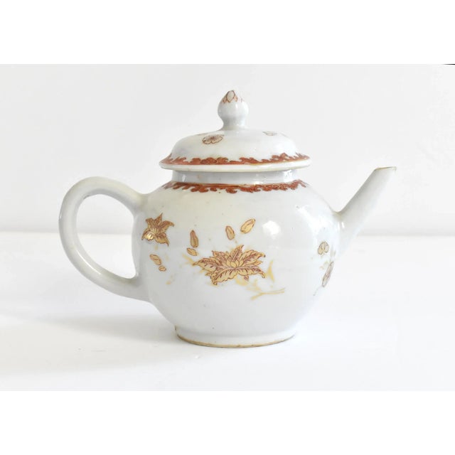 An antique, 18th-century Chinese export porcelain teapot for the European market in a classical shape and a rust and gold...