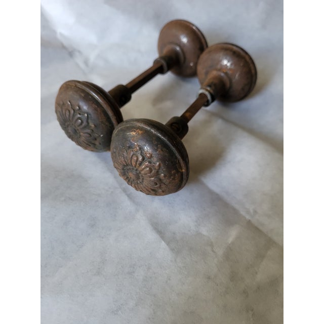 Priced as two door knobs with spindles. This pair of aged, cast bronze passage door knobs was made by Sargent Steel in 1900s.