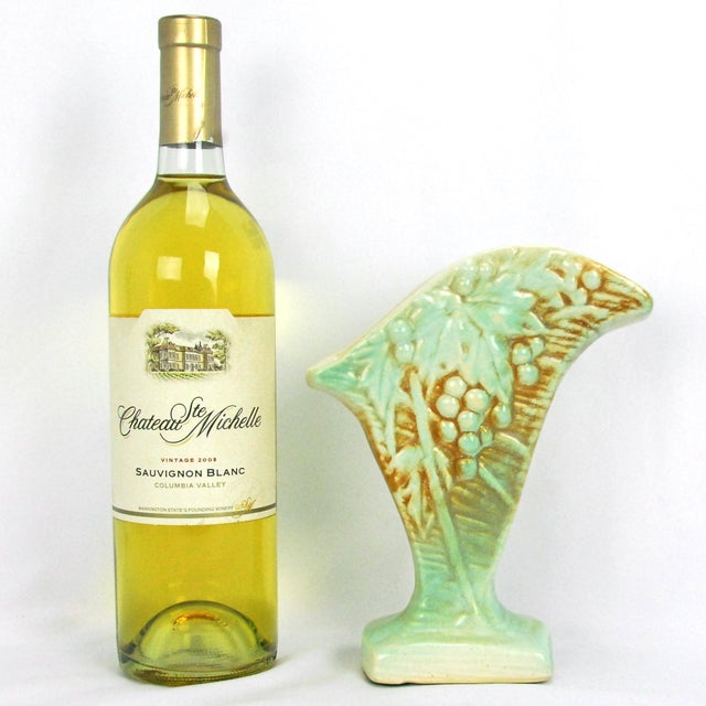 A classic 1940s piece featuring a distinct fan shape adorned with an embossed motif of grape clusters and large leaves....