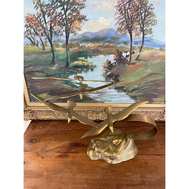 This vintage mid-century modern brass toned sculpture features a dynamic composition of four stylized seagulls in flight....
