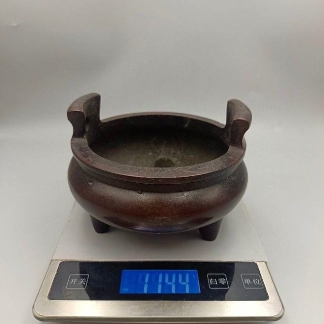 This is a substantial vintage Chinese bronze censer, designed for burning incense. It features a classic tripod form with...