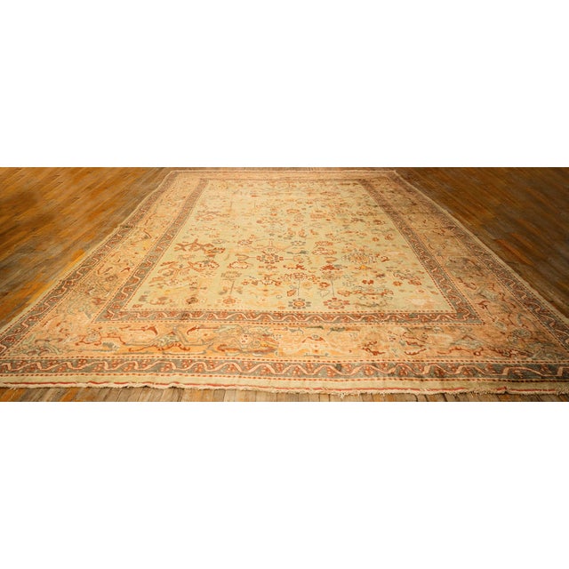 This exceptional Antique Oushak rug, dating to circa 1890, is a standout piece for any high-end collection. Spanning a...