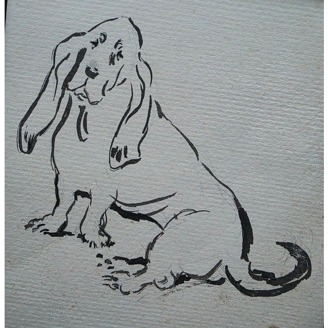 Charming ink drawing on woven paper of a sitting basset hound Black frame with linen liner The strong strokes make this...