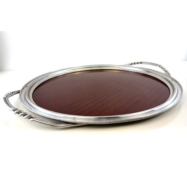 A beautiful vintage serving tray combining a richly finished mahogany center with a silverplate surround, finely beaded...