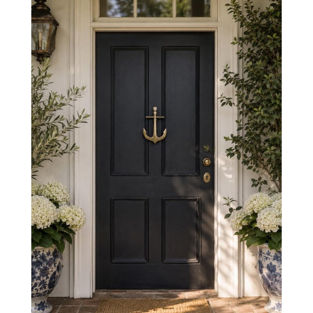 A handsome mid-20th-century cast brass door knocker modeled as a traditional ship’s anchor. The clean, graphic silhouette...