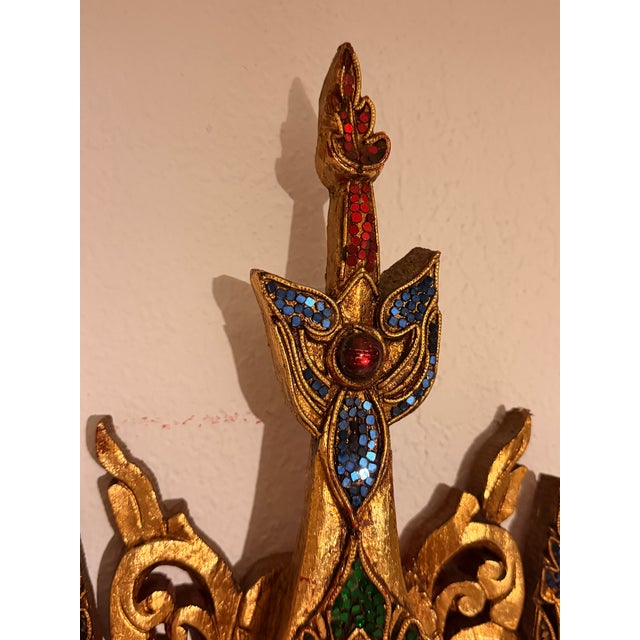 An exceptional hand-carved wall mirror featuring an ornate Southeast Asian–style gilt frame with remarkable craftsmanship...