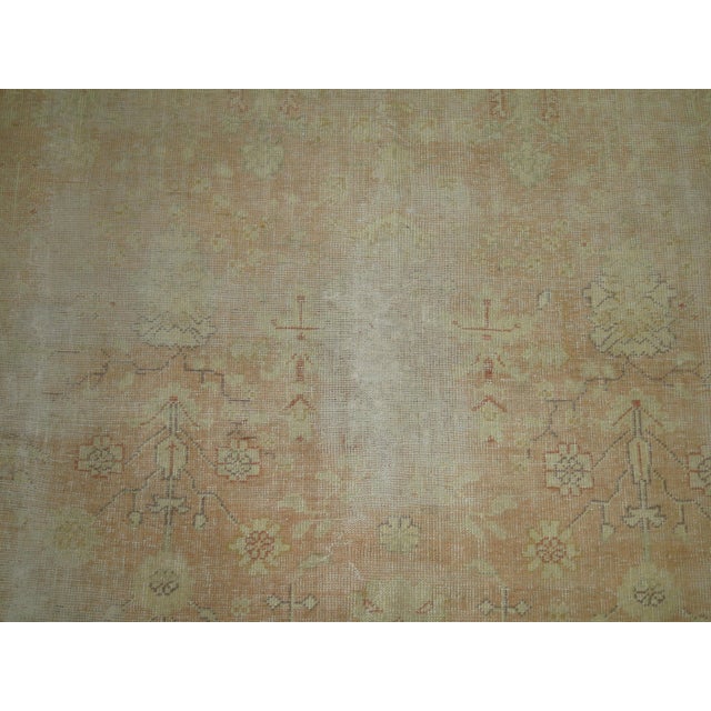 An early 20th century worn oversize antique Turkish Oushak rug in soft peach Measures: 9'8" x 16'7” Turkish Oushak rugs...