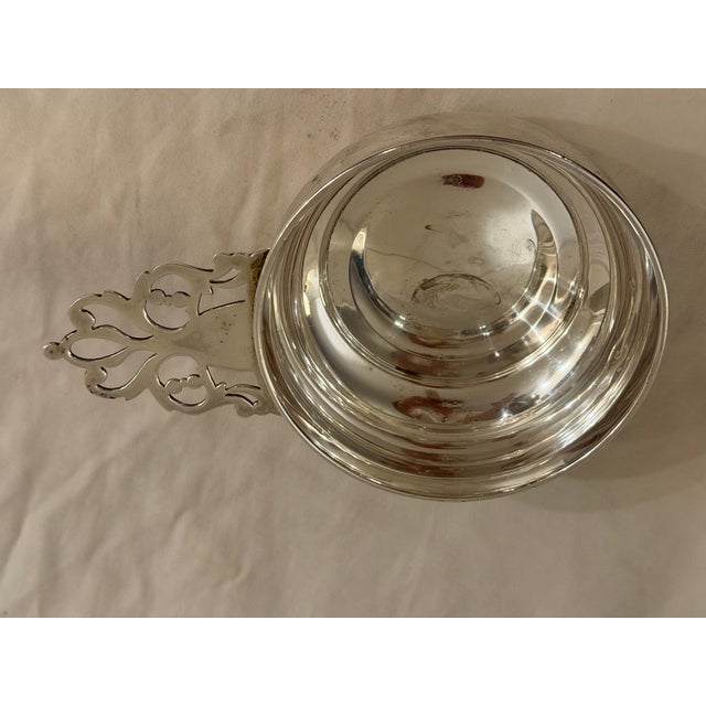 Antique sterling silver porringer, cup-form, featuring a pierced floral handle with ornate motifs and openwork detailing....