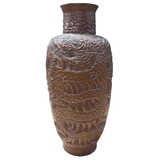 Pre-war hand hammered copper vase showcases an intricately detailed Asian dragon winding gracefully around its surface....