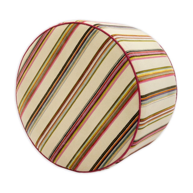 This modern upholstered ottoman features a lively multicolored vertical stripe pattern set against a soft neutral ground,...