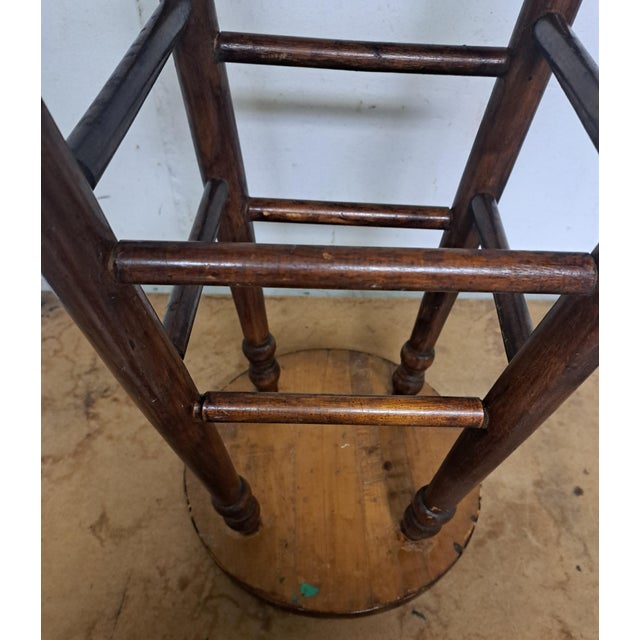 Vintage Wooden Factory Stool. It is 23.75" high. The stool top is 12.75" wide. Good condition, sturdy, with some losses to...