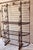 Antique French bakers rack late 19th century scrolling shelf dividers brass accents throughout heavy iron feet at bottom