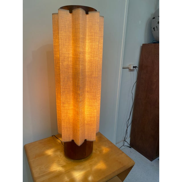 Modeline mid-century table lamp with original cloth shade. Crafted from fabric complimented by a sculptural walnut wooden...