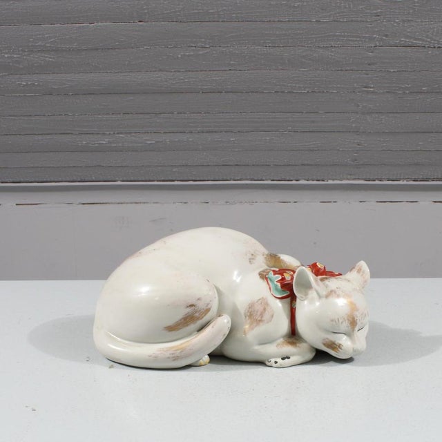 Japanese Kutani Porcelain Sleeping Cat Okimono, “Nemuri-Neko” Style, Taishō–Early Shōwa Period A refined Japanese Kutani...