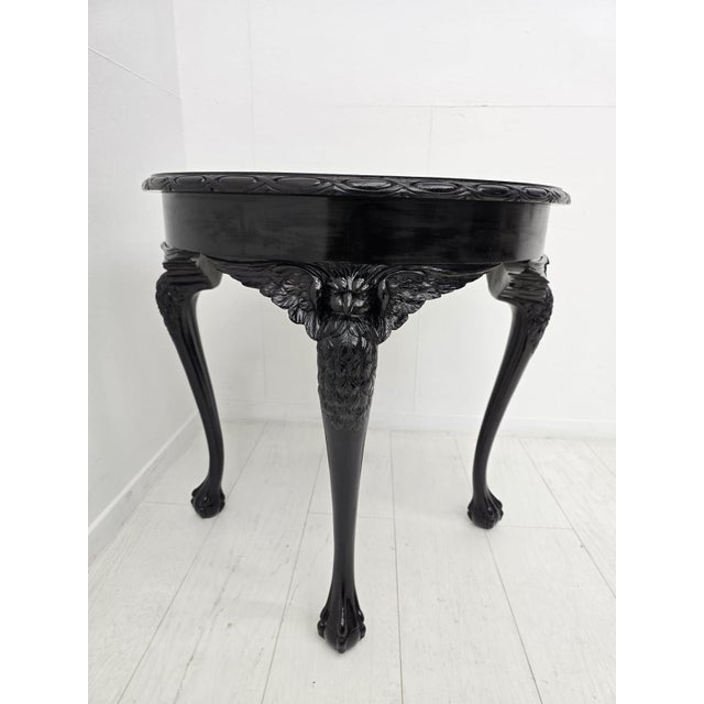 Elegant Italian Rococo side table featuring richly carved shell and foliate motifs, cabriole legs and a dramatic black...