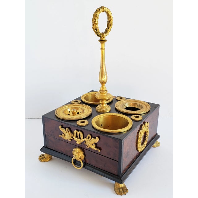 Early 19th Century Empire gilded bronze and burl wood inkwell featuring four vessel, three for ink and one for pounce. The...