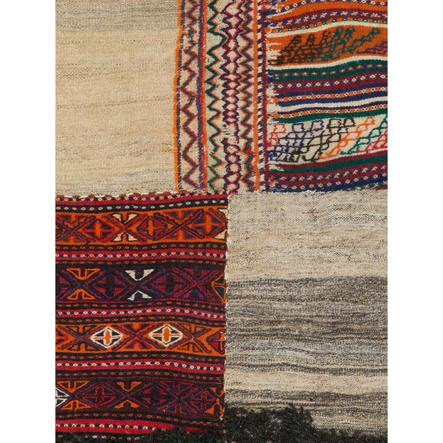 A distinctive Mid-20th century Persian flatweave kilim composed in a striking patchwork arrangement of contrasting panels....