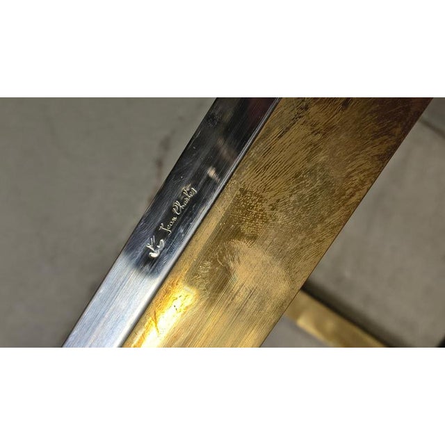 Pair of two tiered brass and chrome side tables by Jean Charles. Smoked glass tops. Good condition Engraved with makers...