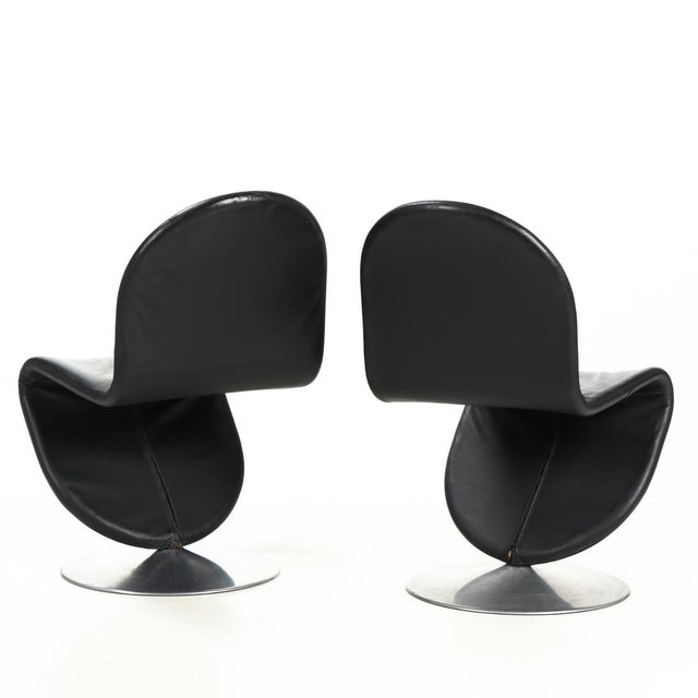 A beautiful pair of absolute design classics: 2 verner panton side chairs (dining chairs), upholstered in black leather....