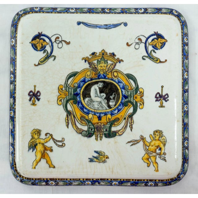 French Faience de Gien trivet or coaster. Vegetal decor with two angel and a bird, in the Italian renaissance style. The...