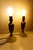 A pair of vintage small brass table lamps featuring elegant urn-shaped silhouettes and luminous opal glass bases. Their...