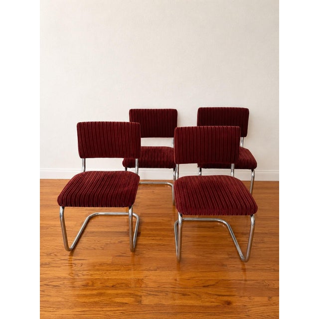 Bauhaus-inspired tubular chrome cantilever design. A striking set of four vintage cantilever dining chairs featuring rich...