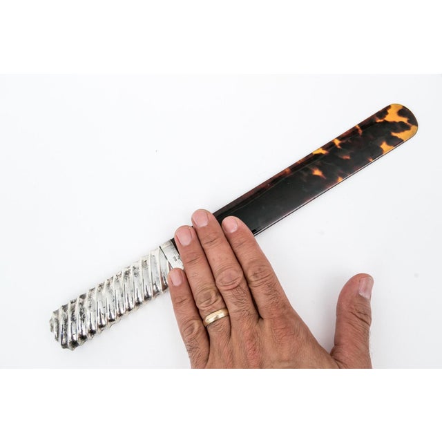 An antique, circa 1892, page turner or paper knife with a sterling silver mounted ribbed handle and faux tortoiseshell...