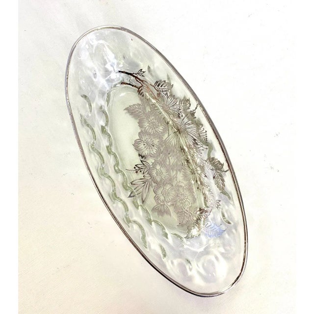 A beveled shallow bowl with a delicate silver floral inlay.