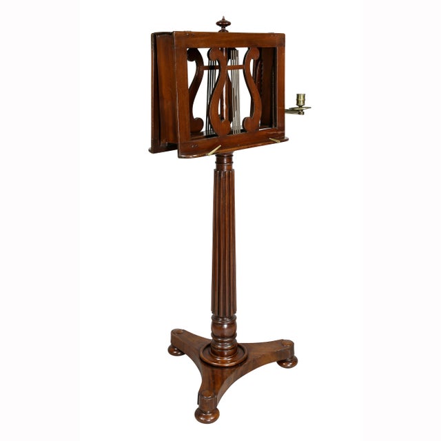 Antique music stand with central finial and double lyre ratcheted sheet music holders and a single attached brass candle...