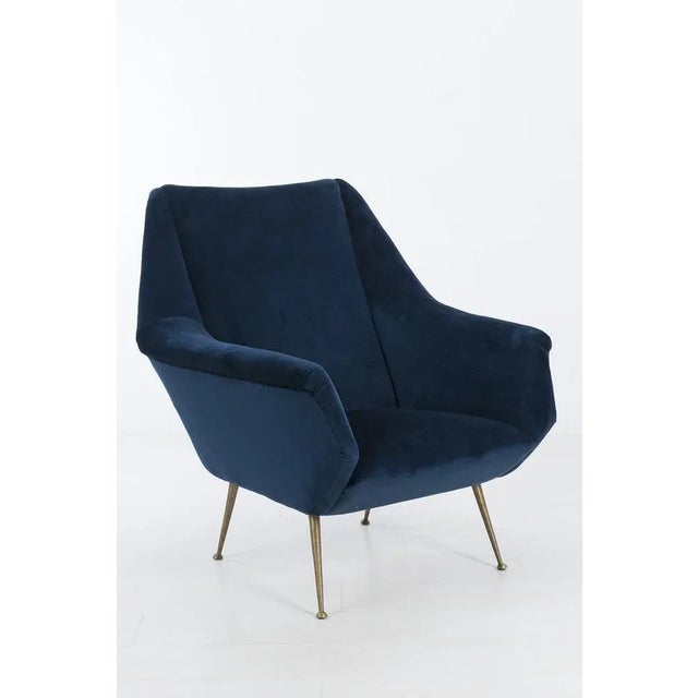 Wonderful Italian armchair with angular shapes and brass legs. The chair has a new dark blue velvet upholstery. In...