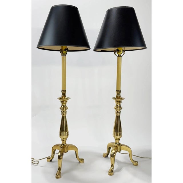 Vintage heavy brass three slipper tripod footed table lamps with original black shades. Measures 29.5"H to top of bulb...