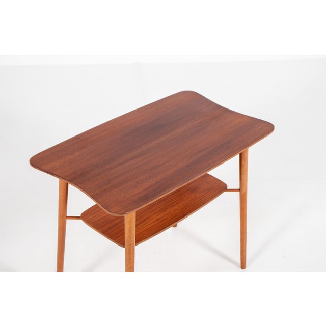 A beautifully elegant side table made in Denmark in the 1960s. The most striking feature is the gently curved and waisted...