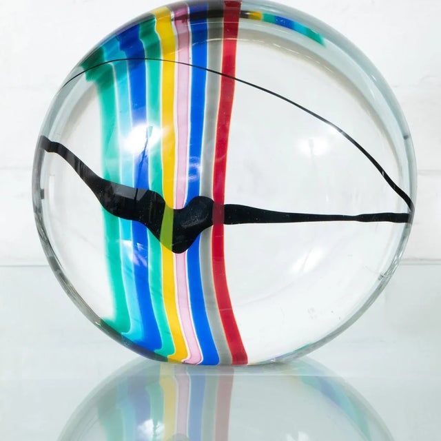 Circular clear Murano glass sculpture with colorful sommerso striping.