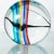 Circular clear Murano glass sculpture with colorful sommerso striping.