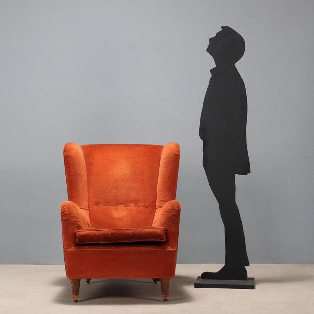 Vintage armchairs with sprung padding and feather cushions, upholstered in original brick-toned fabric; wooden legs. The...